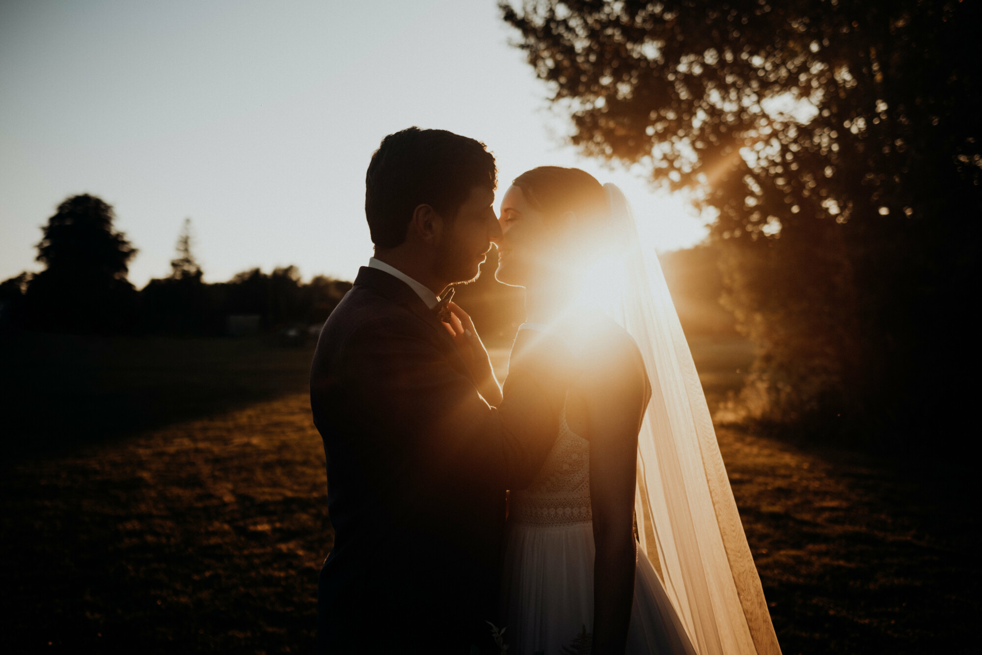 Couple de mariés au coucher du soleil dans le parc du Domaine de la Traxène, lieu de mariage d’exception dans le Nord–Pas-de-Calais. Un cadre romantique et naturel pour célébrer votre mariage près de la Côte d’Opale.