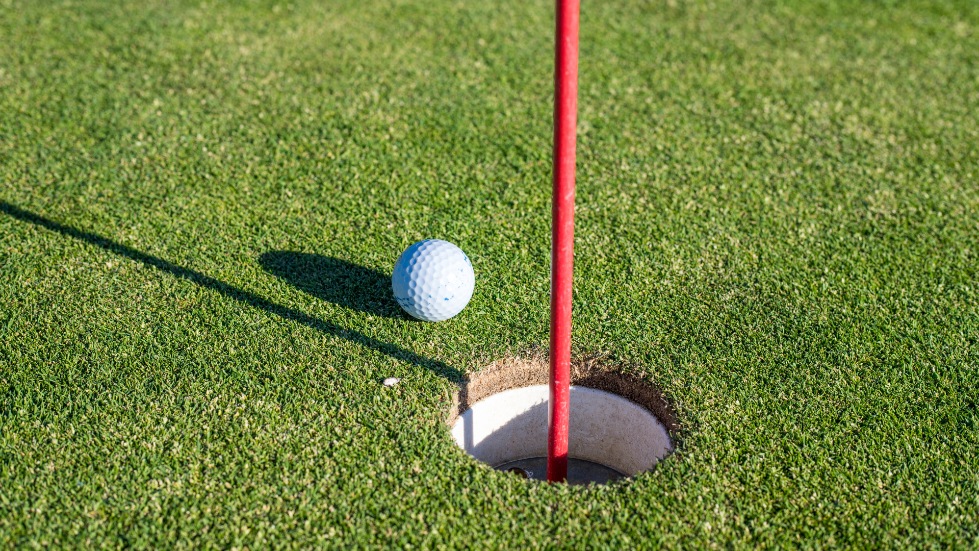 Activité golf au Touquet avec balle sur le green à proximité du trou.