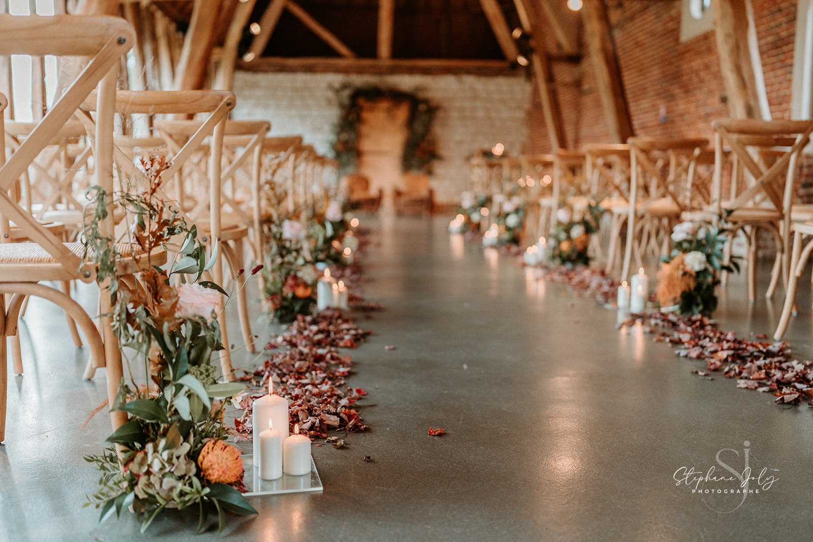 Décoration florale avec bougies pour une cérémonie de mariage en intérieur au Domaine de la Traxène.