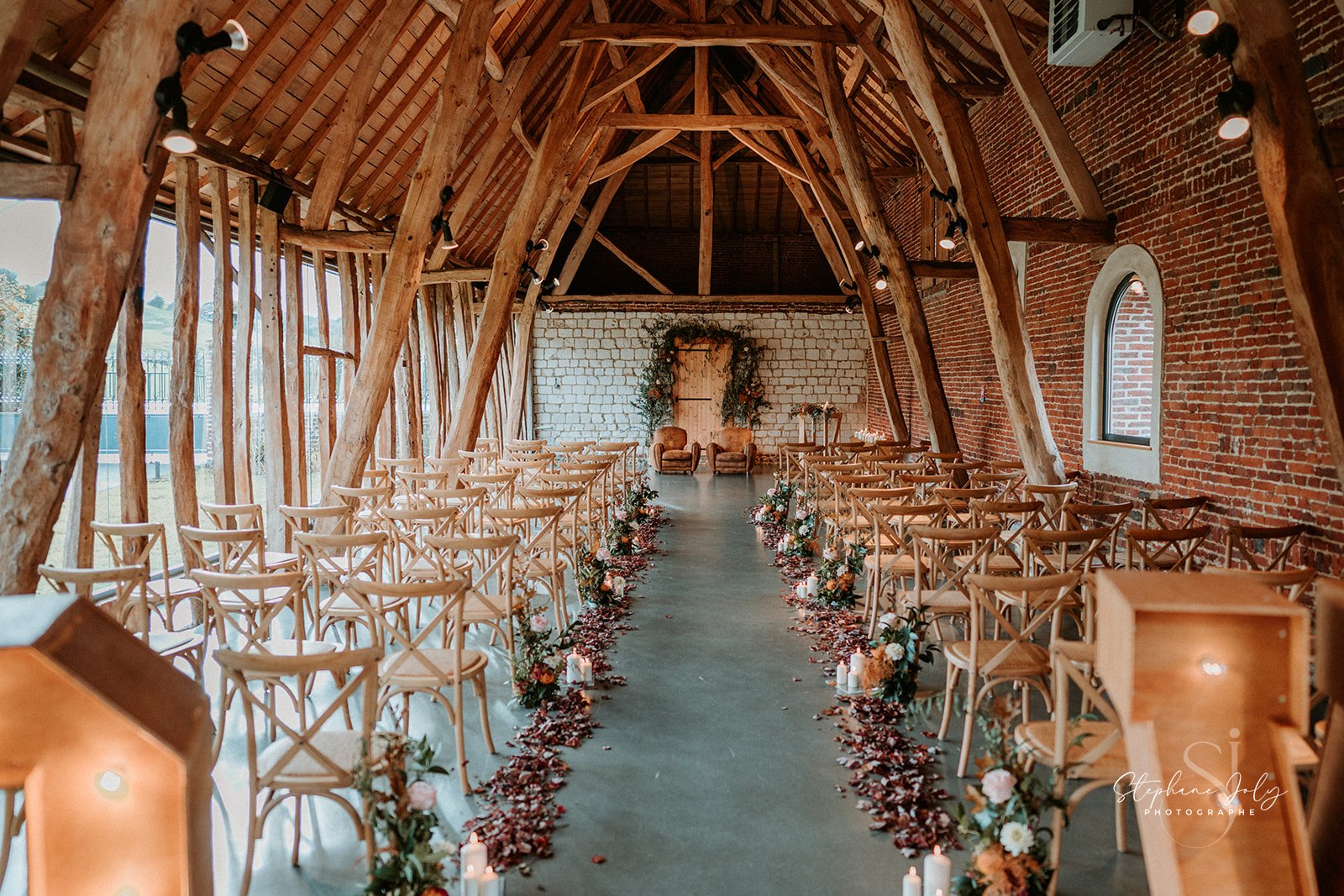 Salle de cérémonie de mariage décorée de fleurs et de bougies au Domaine de la Traxène.