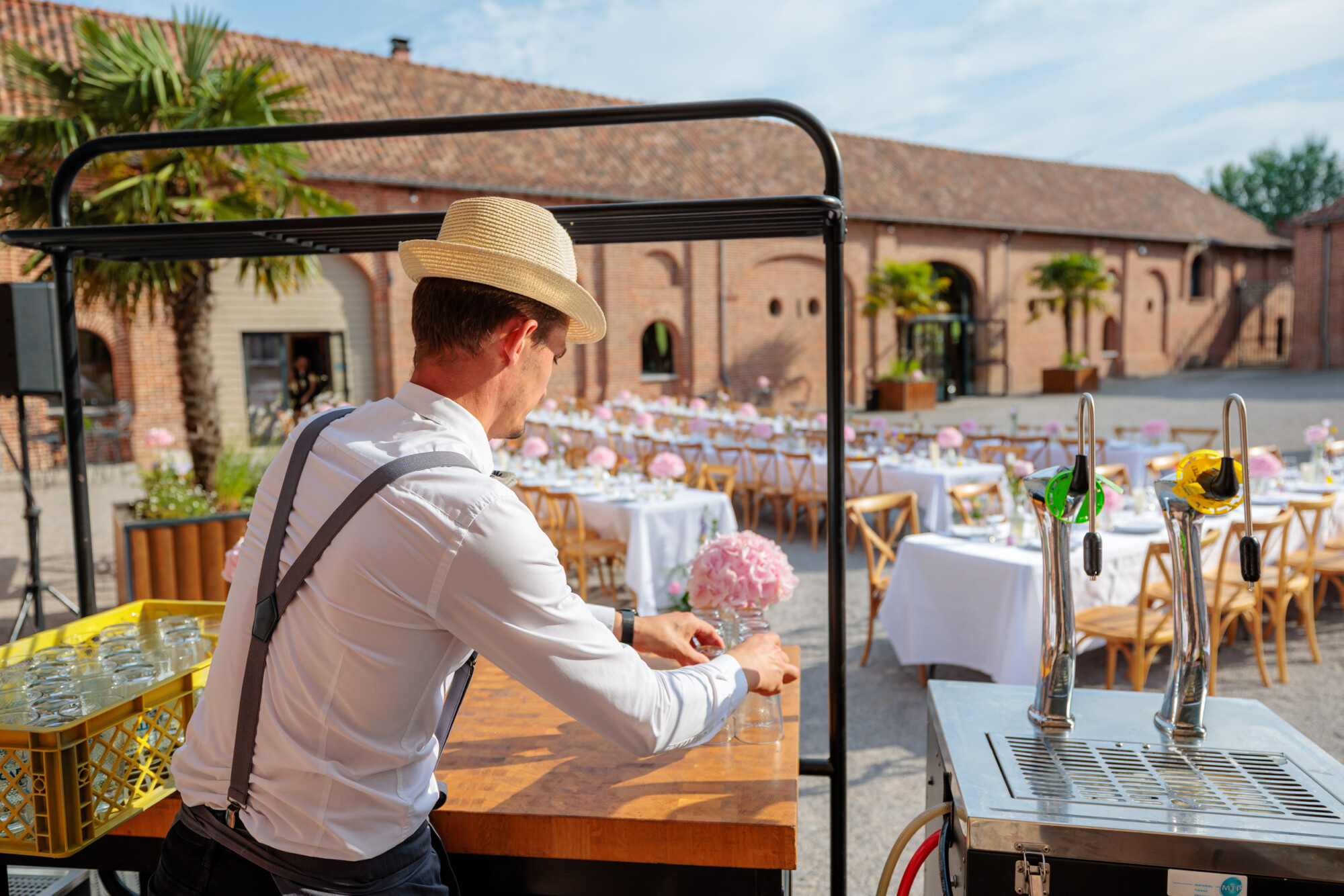 Prestataire préparant le service des boissons pour une réception de mariage sur plusieurs jours au Domaine de la Traxène.