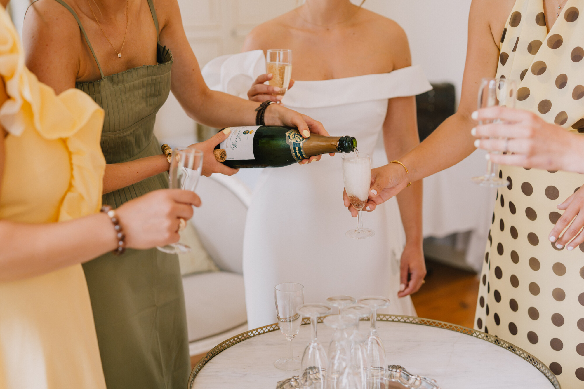 EVJF avant le mariage avec la future mariée et ses proches partageant une coupe de champagne lors des préparatifs.