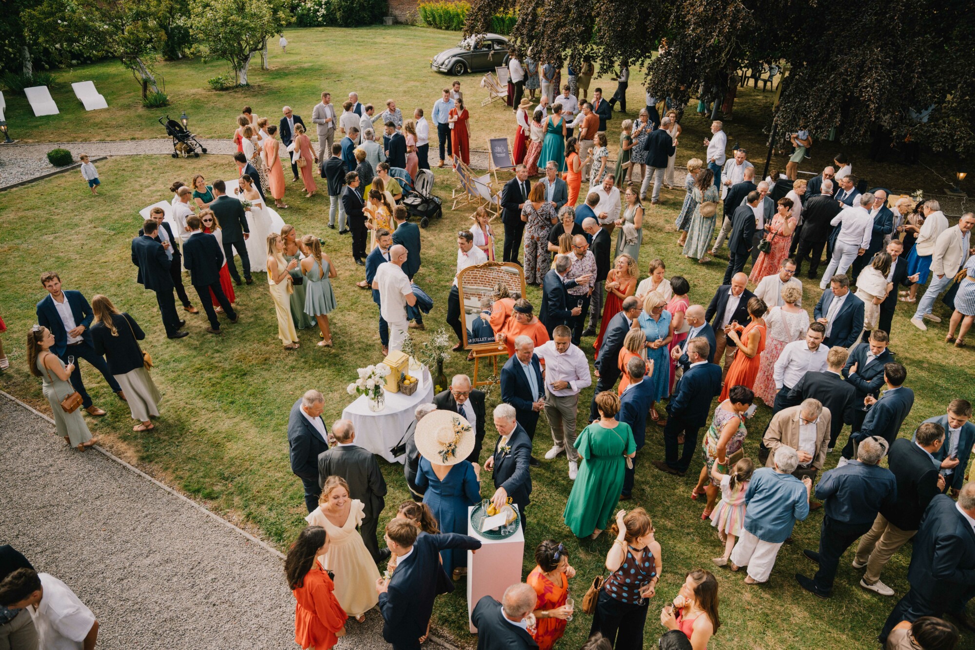 Cocktail de mariage en plein air avec les mariés et leurs invités dans les jardins du Domaine de la Traxène.